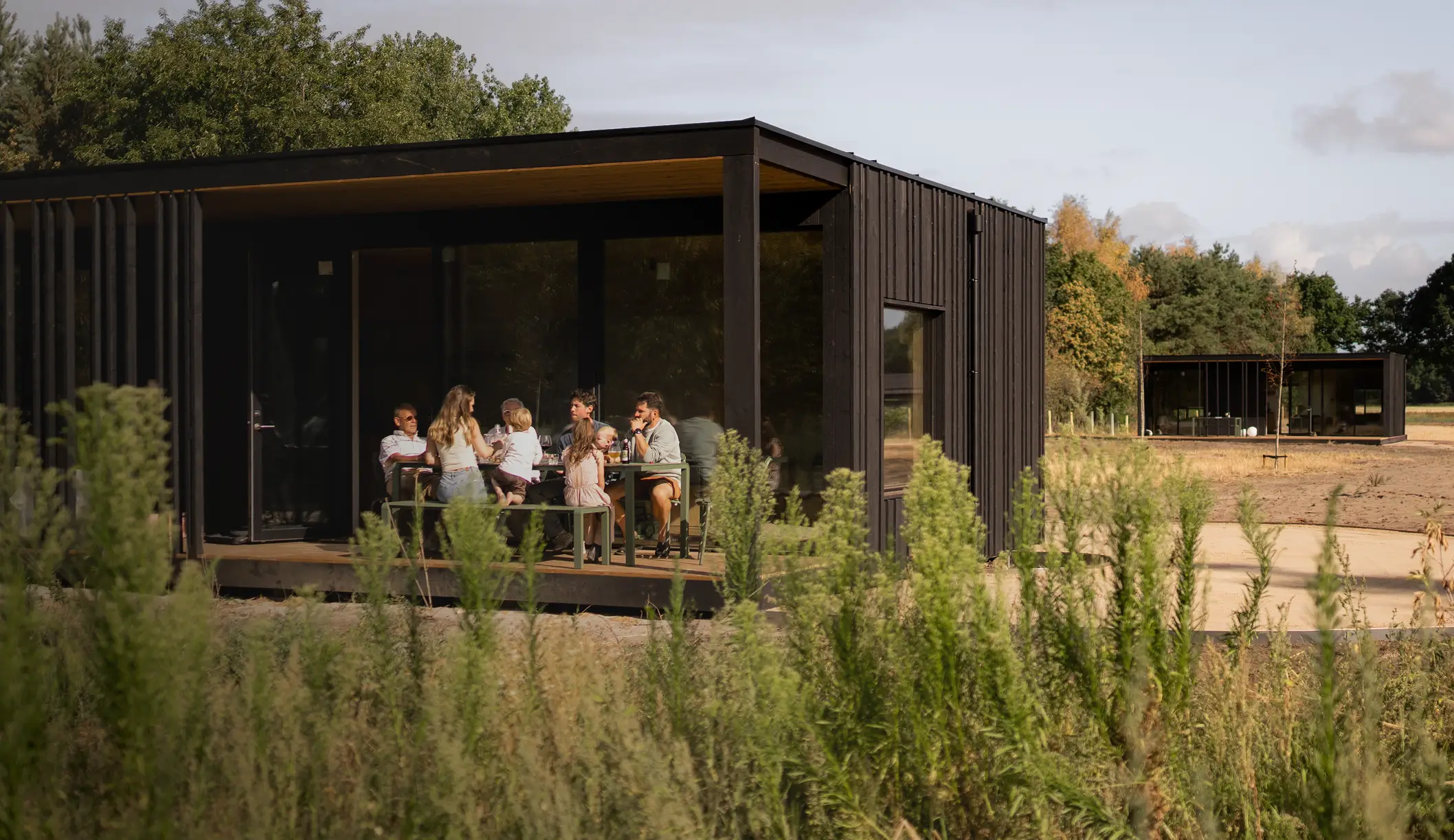Eco by Nature KONGA cabin exterior with guests on the terrace