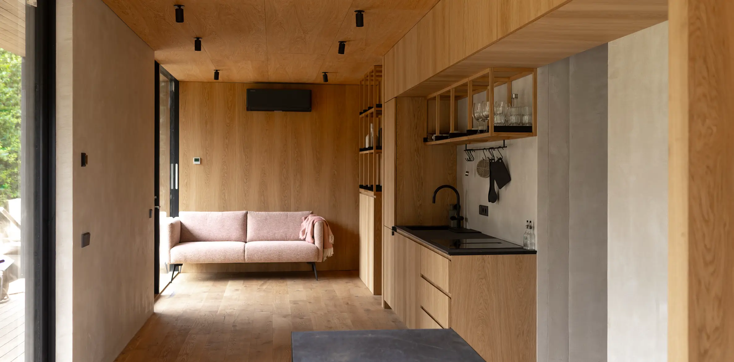 Living area with sofa and kitchen in a KONGA cabin at Eco by Nature